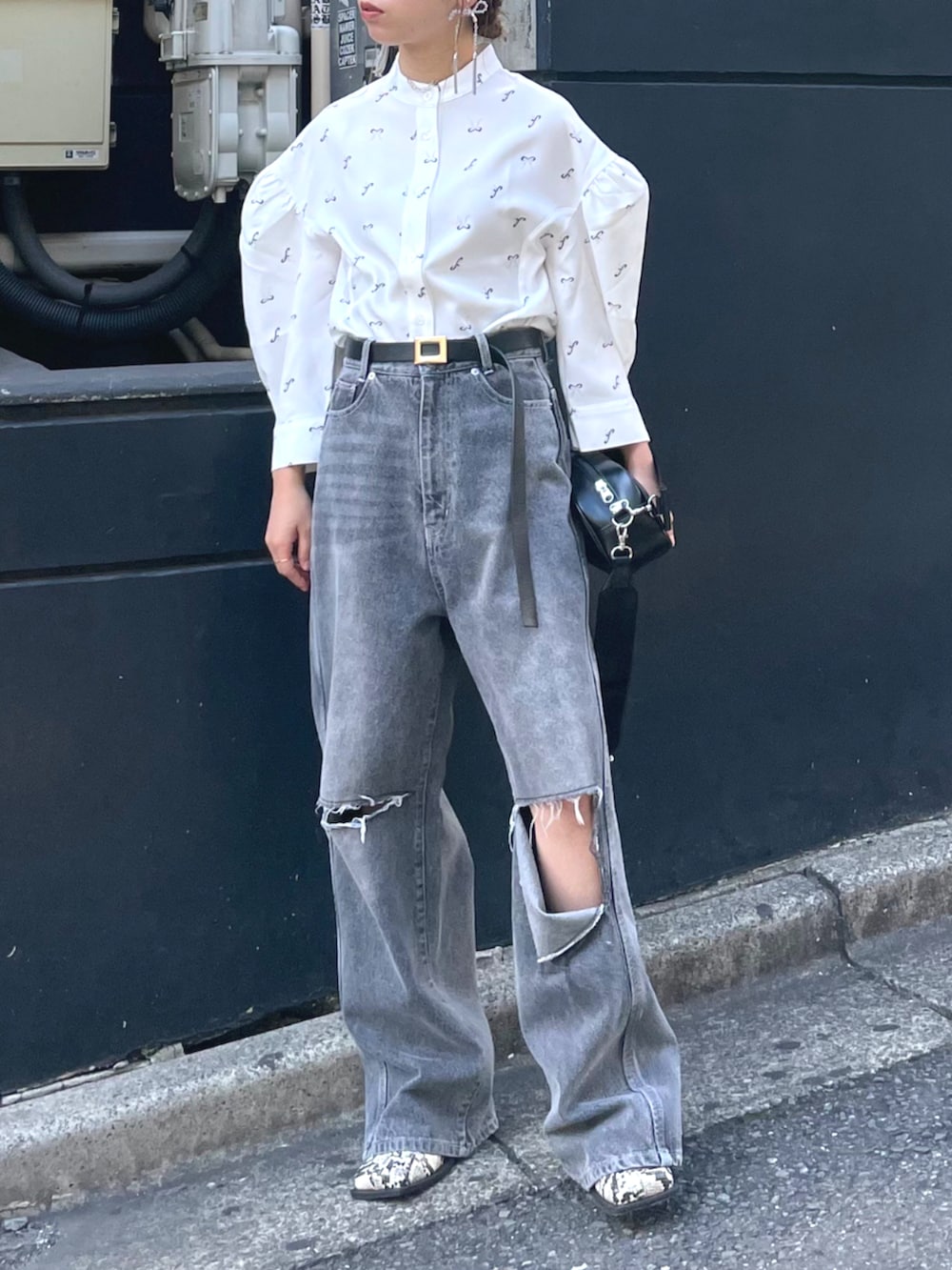 ブラック系のショルダーバッグ、ホワイト系のシャツ/ブラウス、ブルー系のデニムパンツを着用したレディースの秋コーディネートの2枚目の写真