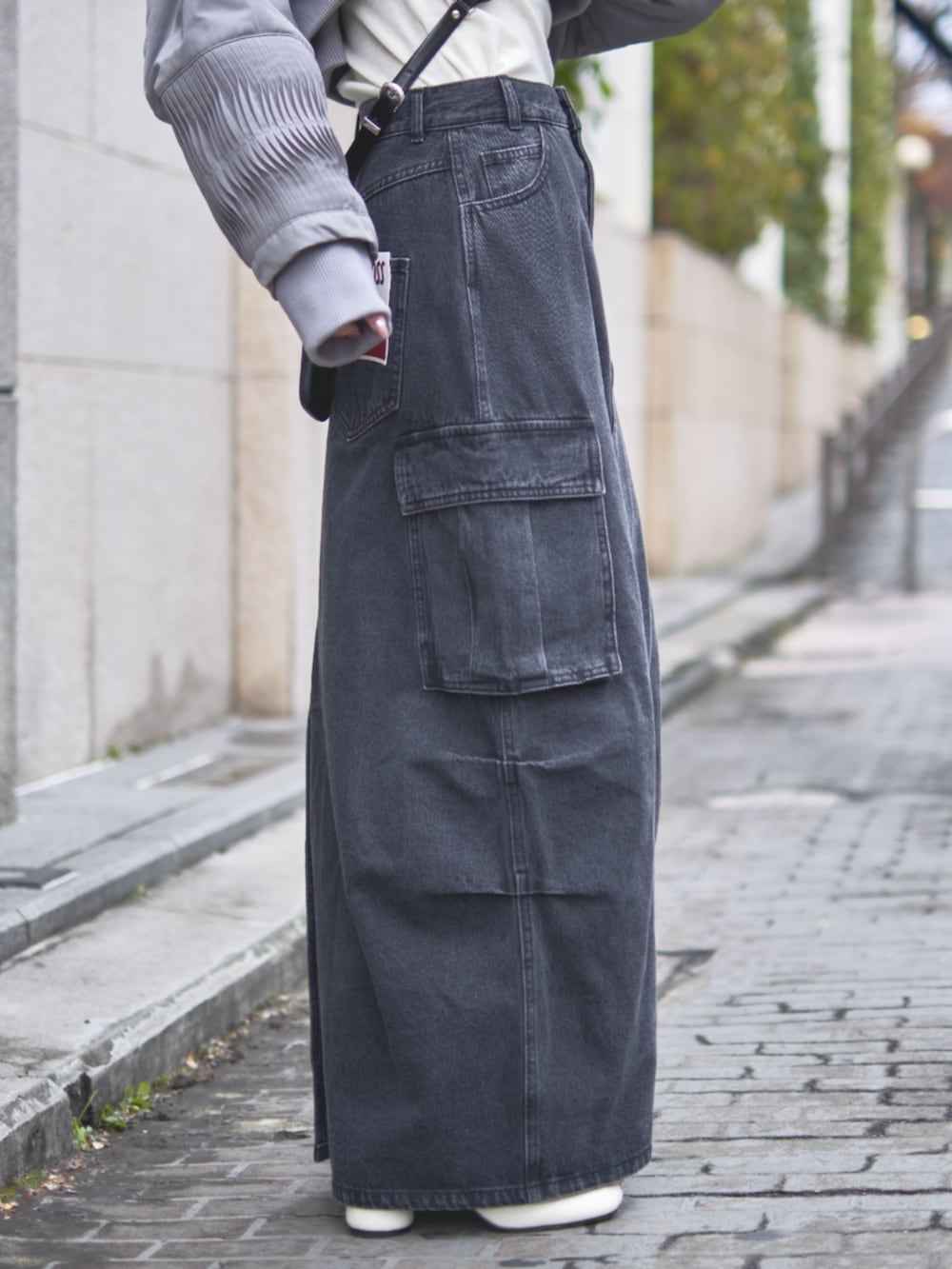 ブラック系のデニムスカート、ブラック系のスマホグッズを着用したレディースの冬コーディネートの6枚目の写真