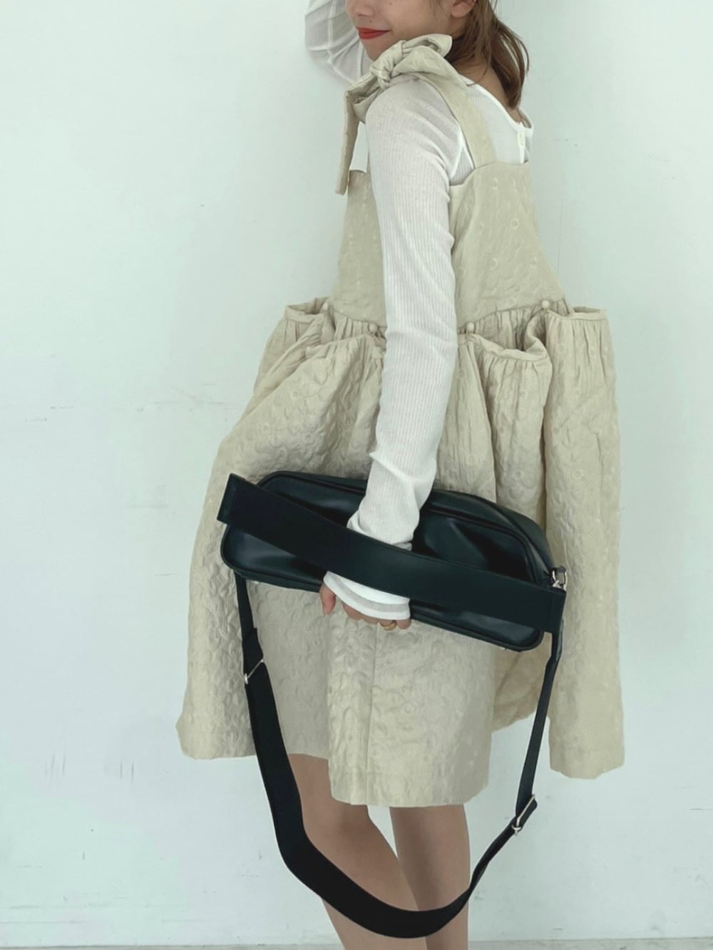 ブラック系のショルダーバッグ、ホワイト系のワンピースを着用したレディースの秋コーディネートの3枚目の写真