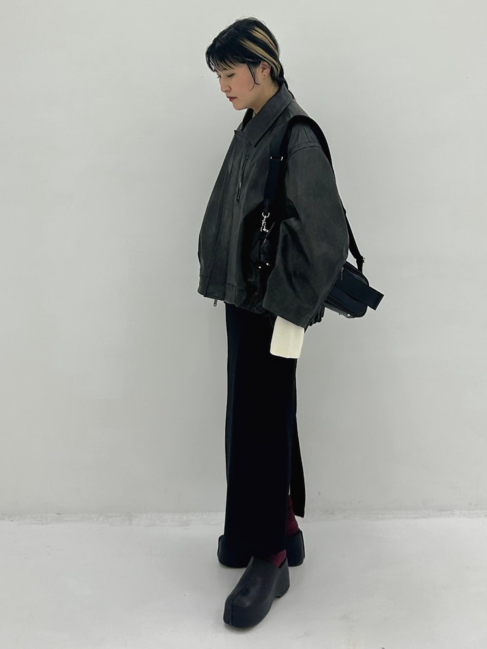 ブラウン系のブルゾン、ブラック系のショルダーバッグを着用したレディースの秋コーディネートの2枚目の写真