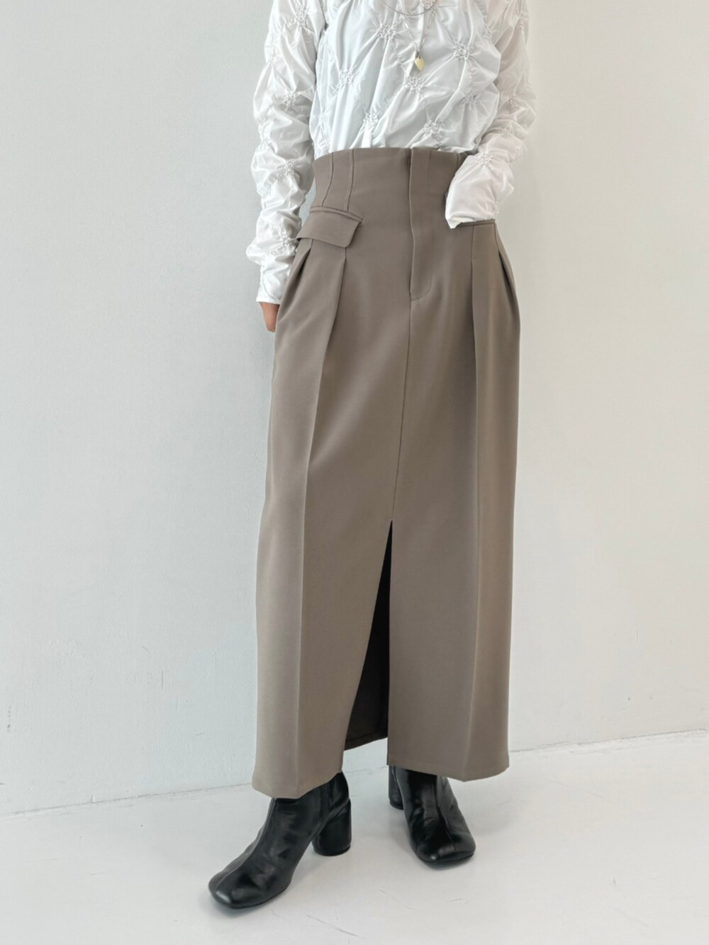 ホワイト系のTシャツ/カットソー、グレー系のスカートを着用したレディースの秋コーディネートの4枚目の写真