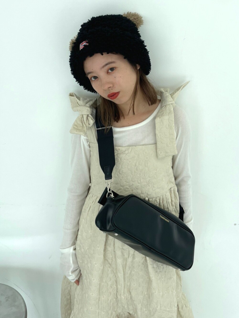 ブラック系のショルダーバッグ、ブラウン系のバレエシューズ、ホワイト系のワンピースを着用したレディースの秋コーディネートの3枚目の写真