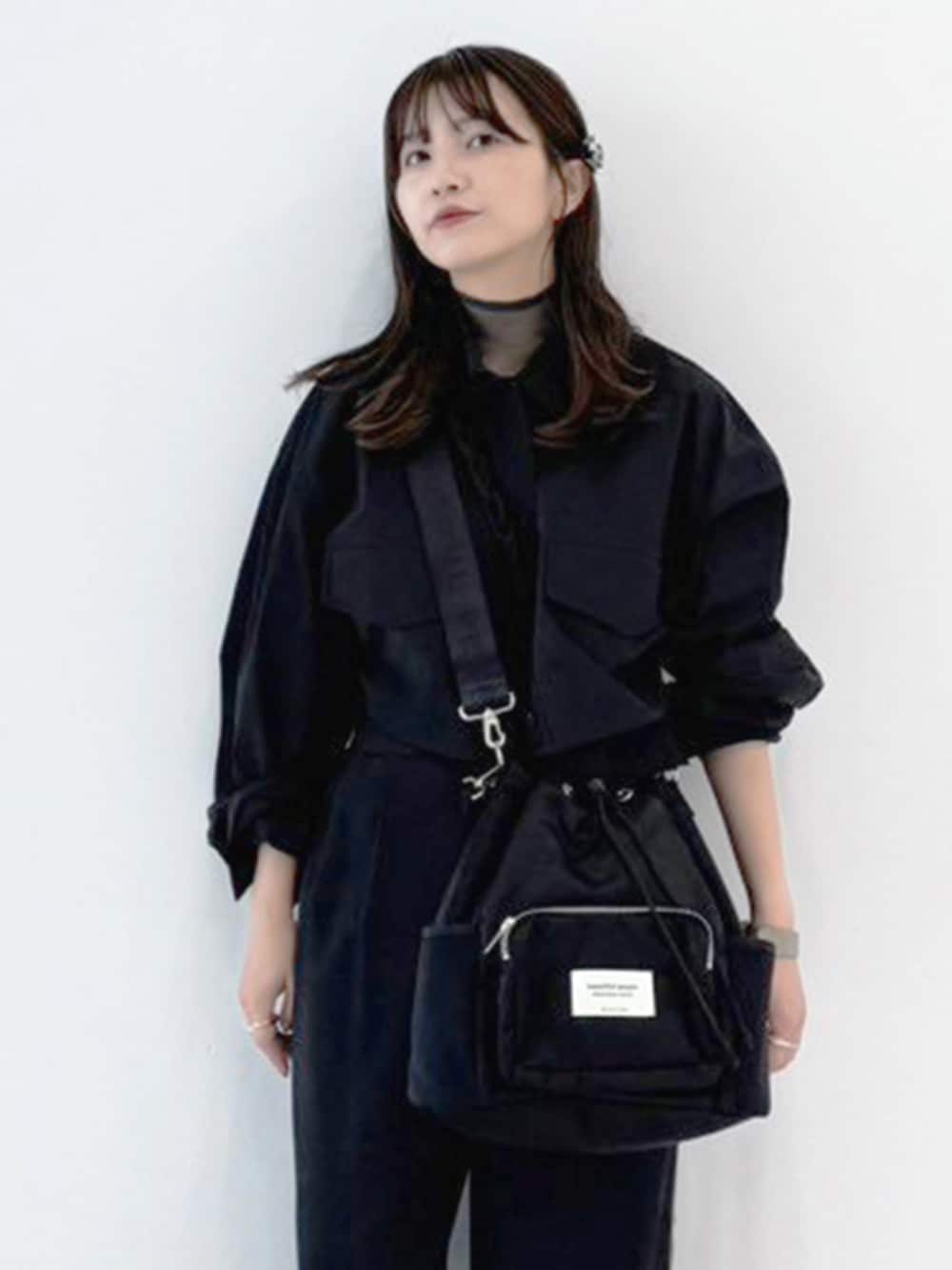 ブラック系のハンドバッグを着用したレディースの冬コーディネートの2枚目の写真