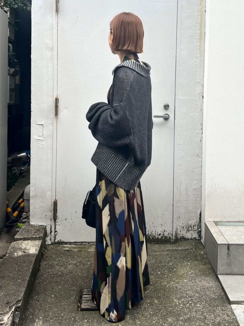 ブラック系のハンドバッグ、ブラック系のニット/セーターを着用したレディースの秋コーディネートの2枚目の写真