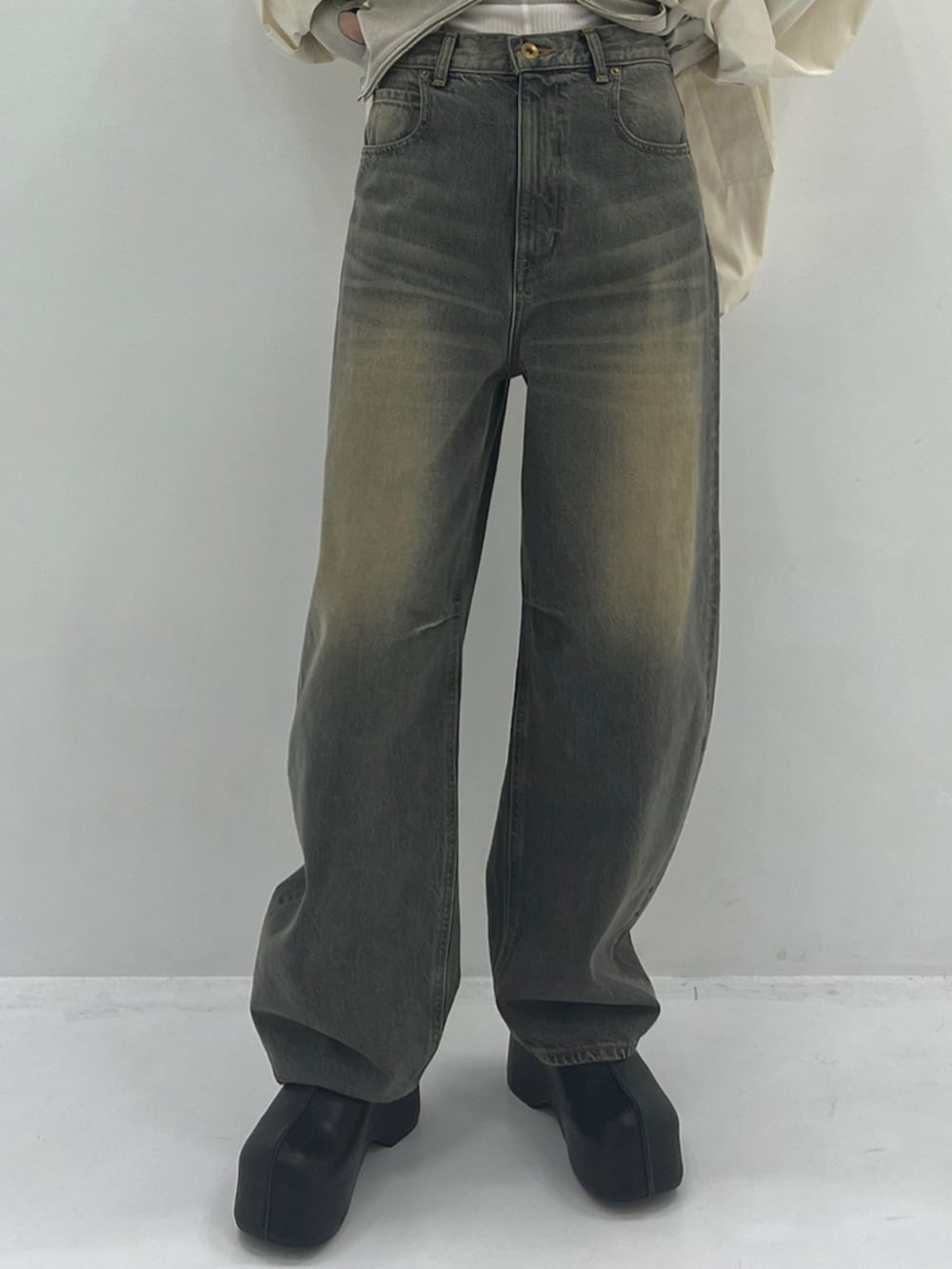 ブルー系のデニムパンツ、ブラック系のスリッポン、ホワイト系のブルゾンを着用したレディースの秋コーディネートの4枚目の写真