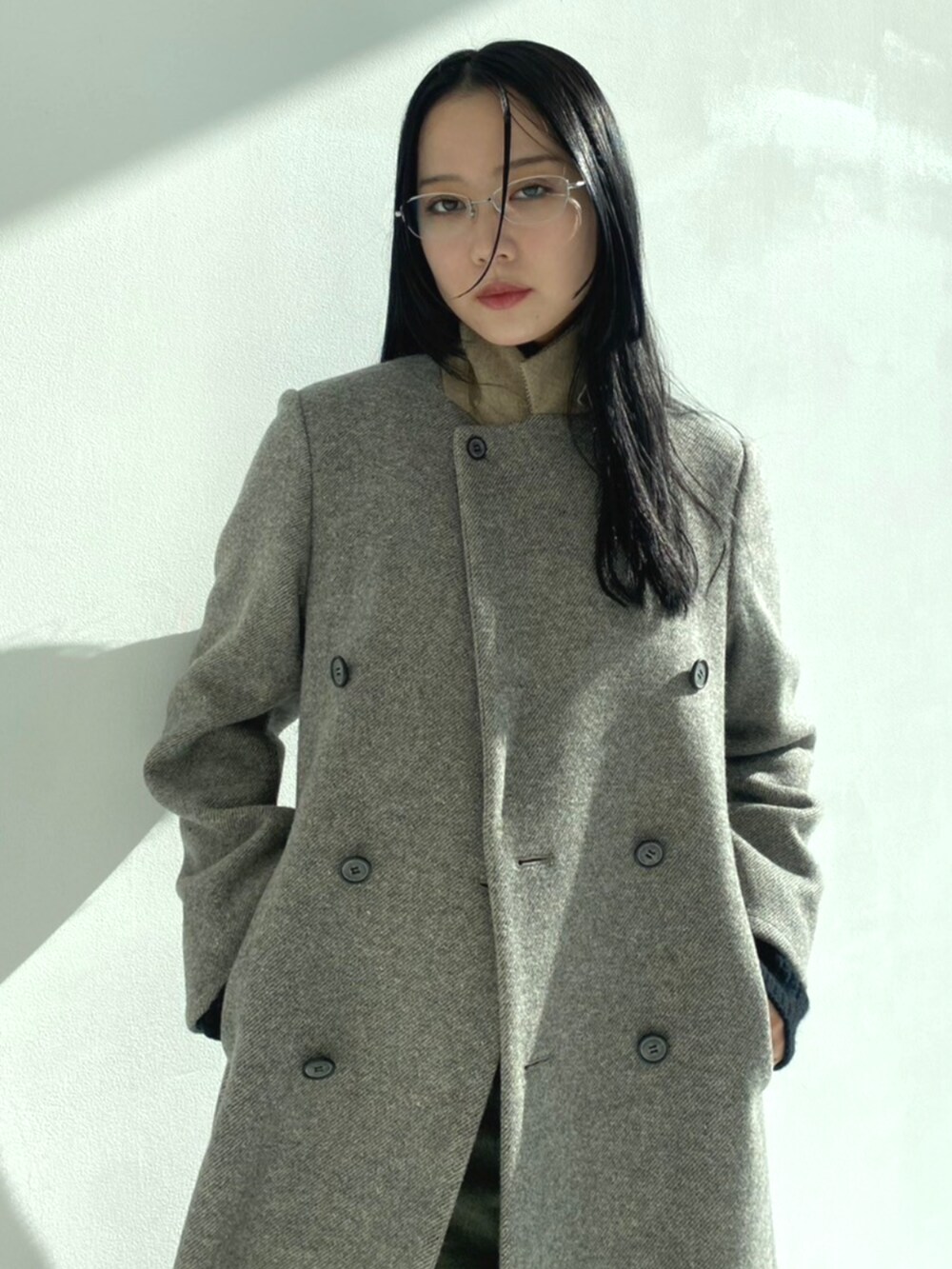 レッド系のパンプス、ブラック系のデニムパンツ、グレー系のチェスターコートを着用したレディースの秋コーディネートの4枚目の写真