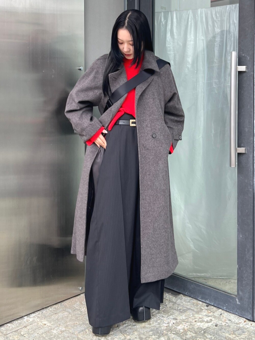 レッド系のニット/セーター、グレー系のその他アウターを着用したレディースの秋コーディネートの2枚目の写真