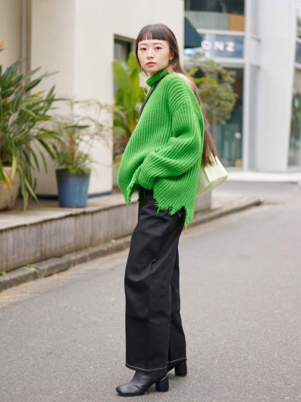 ブラック系のデニムパンツを着用したレディースの冬コーディネートの2枚目の写真