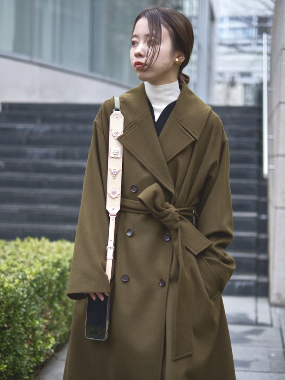 グリーン系のチェスターコートを着用したレディースの冬コーディネートの6枚目の写真