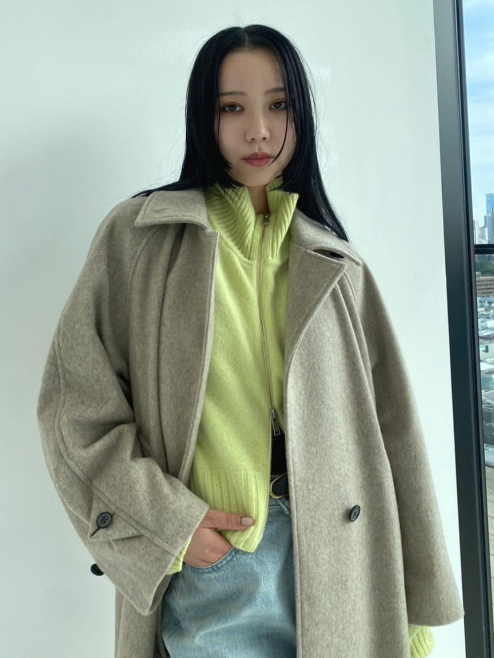 ベージュ系のその他アウター、グリーン系のニット/セーターを着用したレディースの秋コーディネートの2枚目の写真