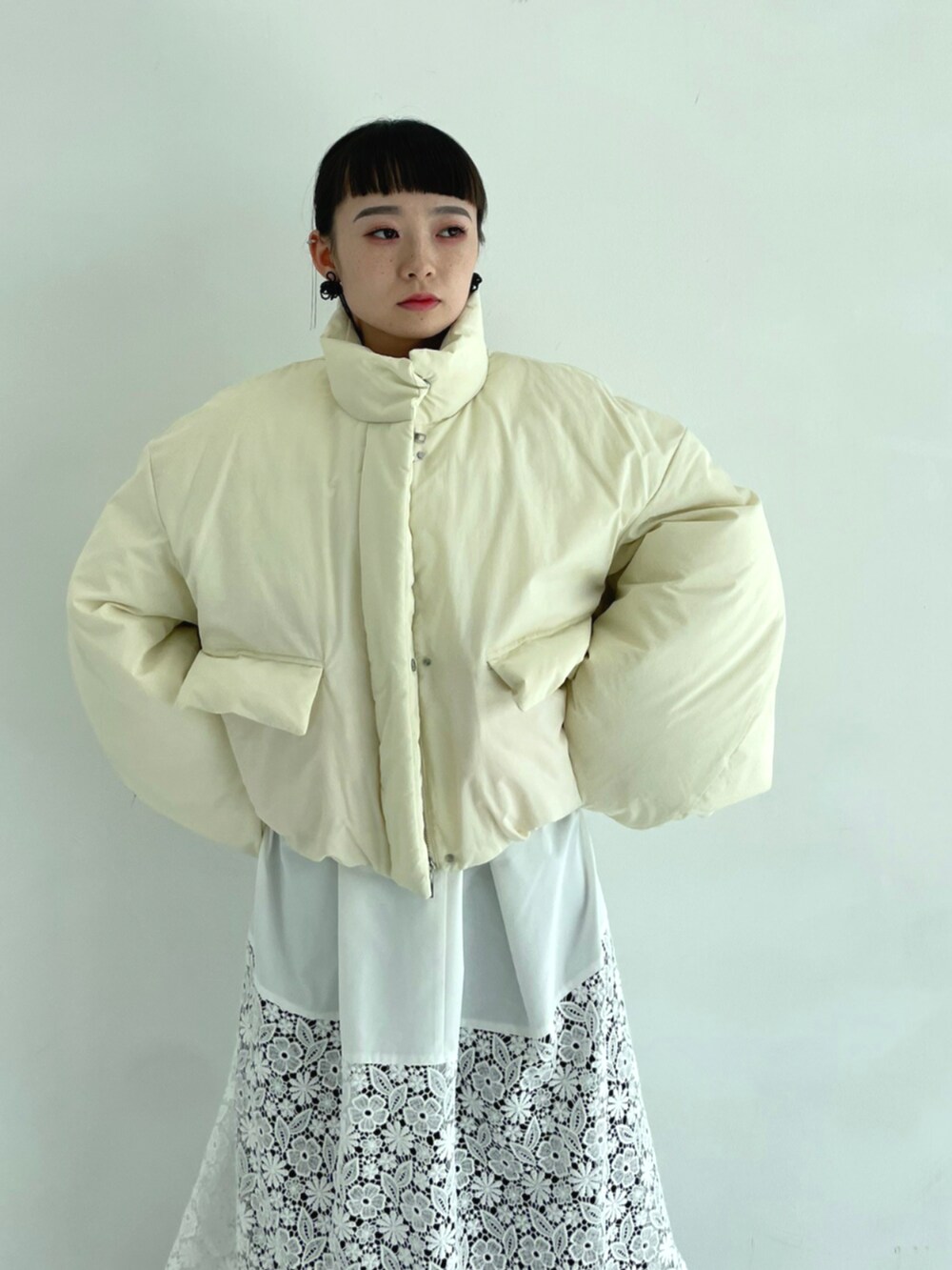 ホワイト系のワンピース、ベージュ系のダウンジャケット/コートを着用したレディースの秋コーディネートの4枚目の写真