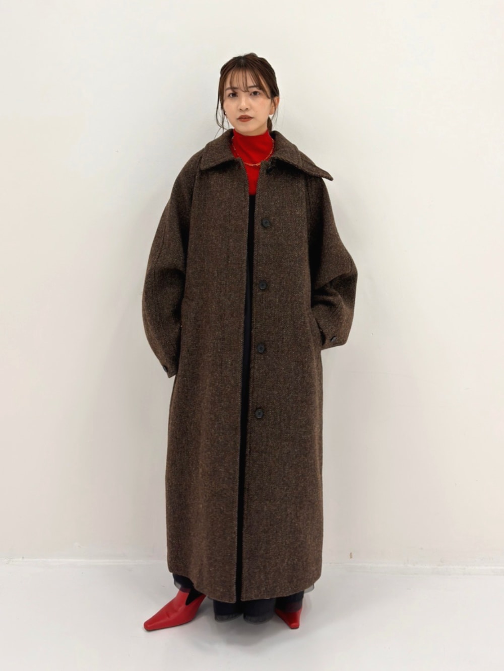 ブラウン系のステンカラーコートを着用したレディースの秋コーディネートの2枚目の写真