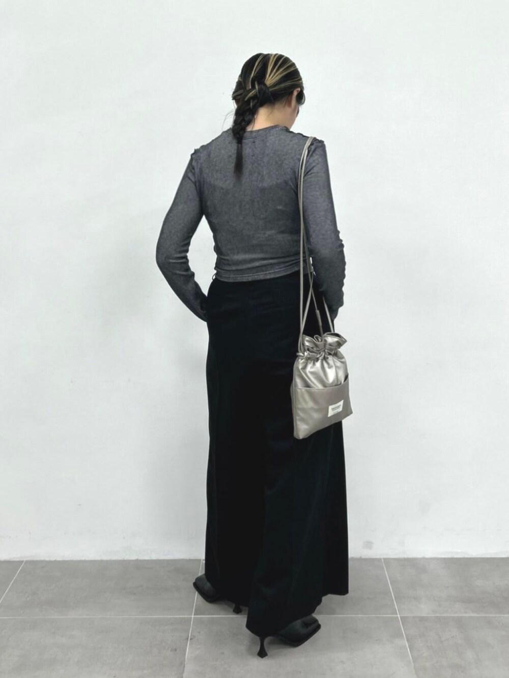 ブラック系のスラックス、グレー系のTシャツ/カットソー、シルバー系のショルダーバッグを着用したレディースの秋コーディネートの2枚目の写真