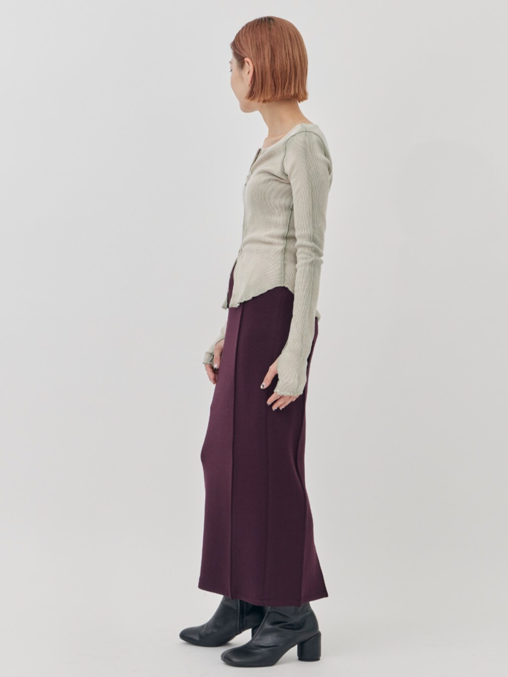 ベージュ系のカーディガン/ボレロ、レッド系のスカートを着用したレディースの秋コーディネートの2枚目の写真