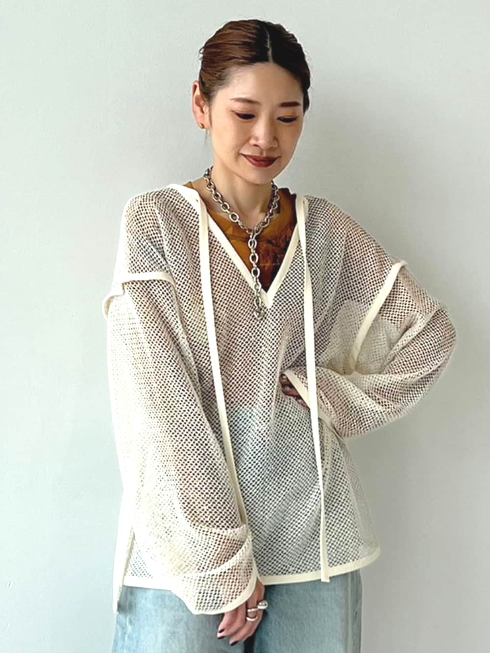 ホワイト系のTシャツ/カットソー、ブラウン系のTシャツ/カットソー、ブルー系のデニムパンツを着用したレディースの冬コーディネートの2枚目の写真