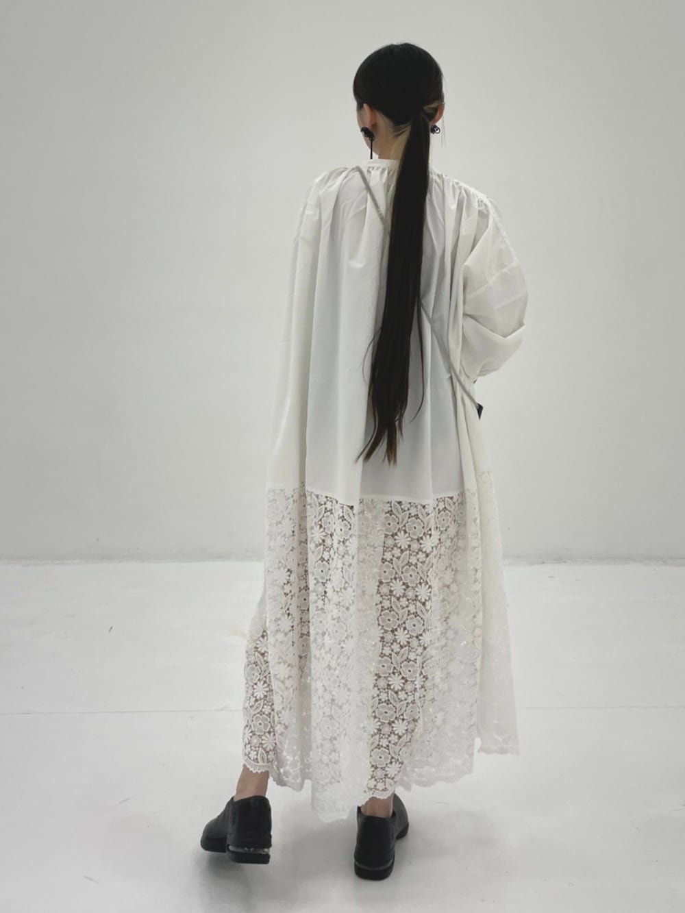 ホワイト系のワンピース、ブラック系のショルダーバッグを着用したレディースの秋コーディネートの2枚目の写真