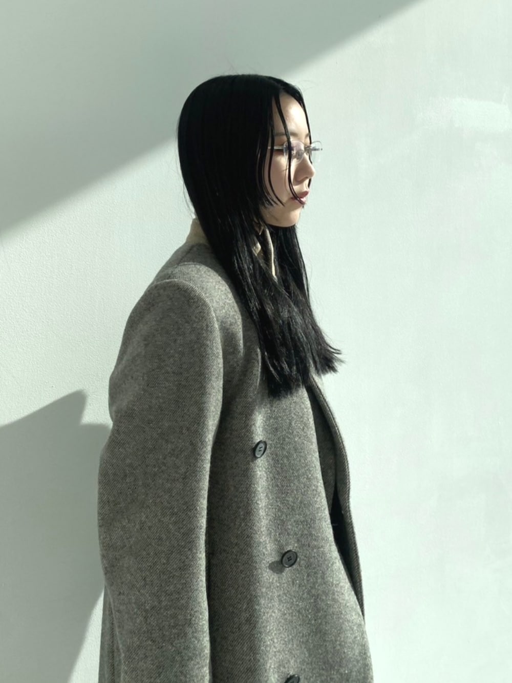 レッド系のパンプス、ブラック系のデニムパンツ、グレー系のチェスターコートを着用したレディースの秋コーディネートの5枚目の写真