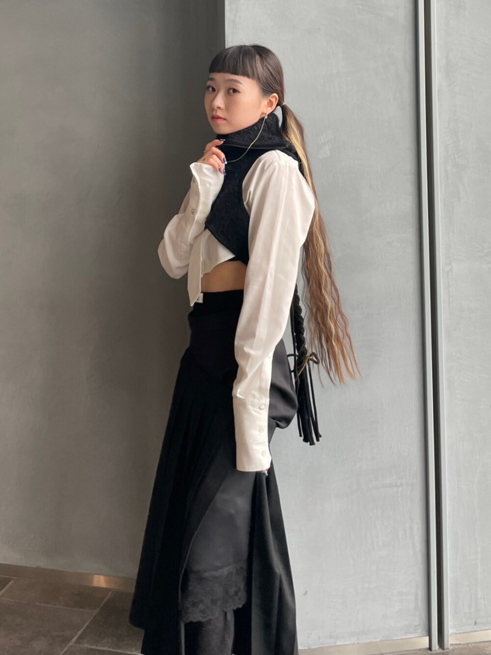 ブラック系のスカート、ブラック系のベストを着用したレディースの秋コーディネートの2枚目の写真