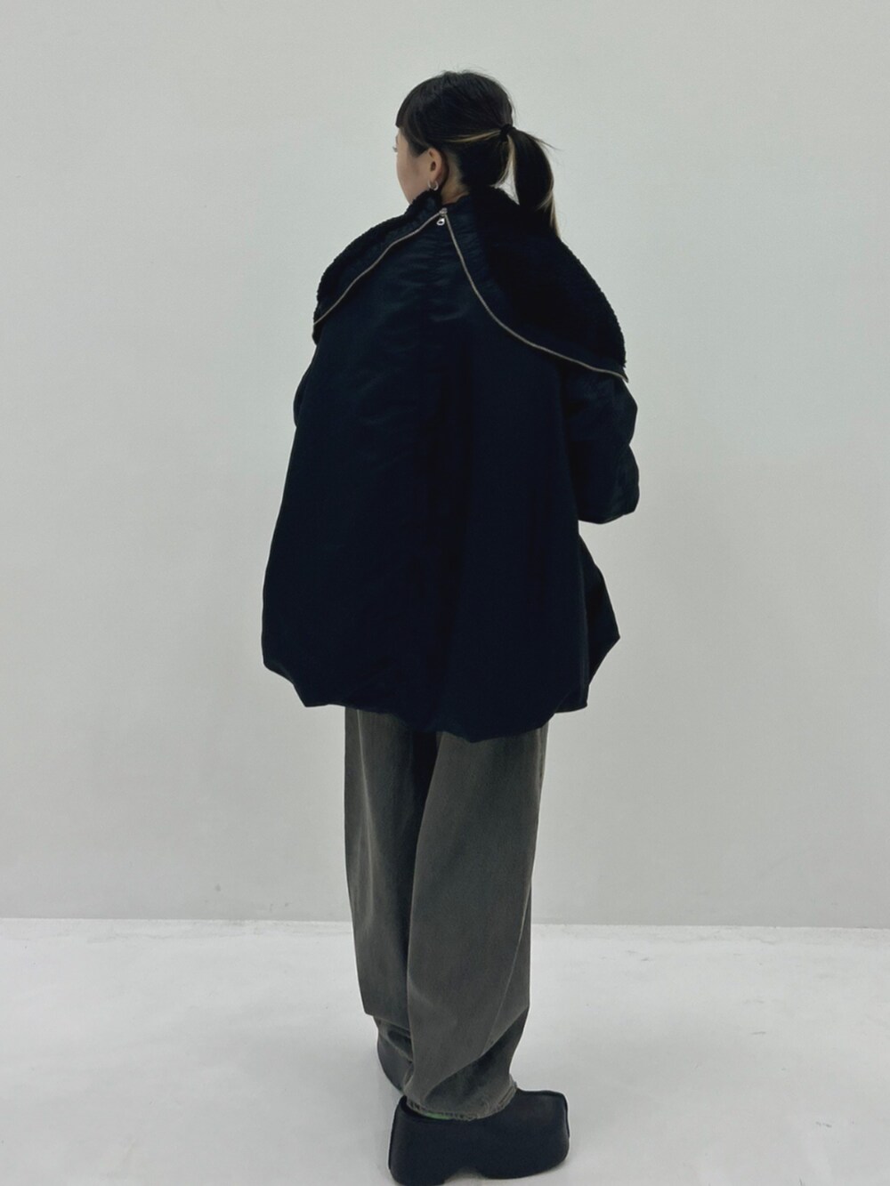 ブラック系のブルゾン、ブラック系のデニムパンツ、ブラック系のスリッポンを着用したレディースの秋コーディネートの3枚目の写真