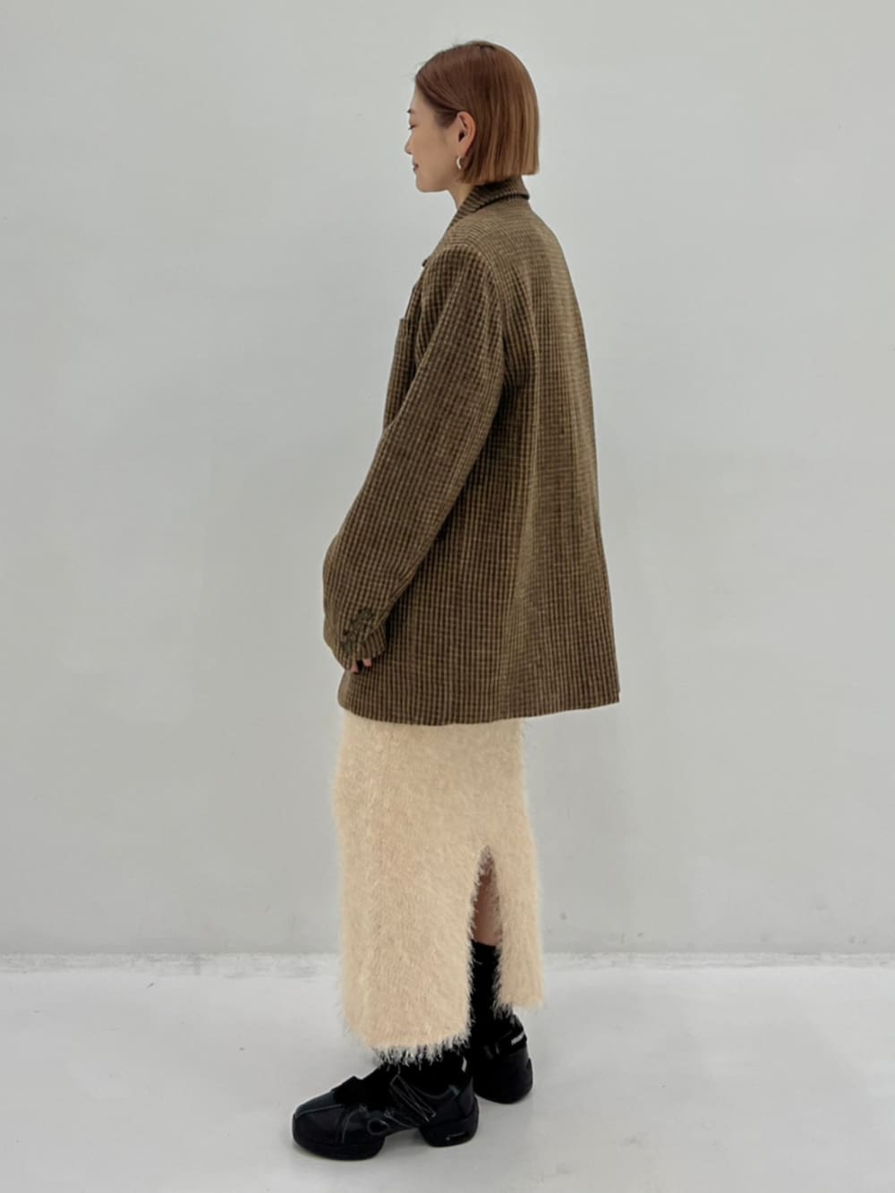 イエロー系のテーラードジャケット、ホワイト系のTシャツ/カットソー、ホワイト系のスカートを着用したレディースの秋コーディネートの2枚目の写真