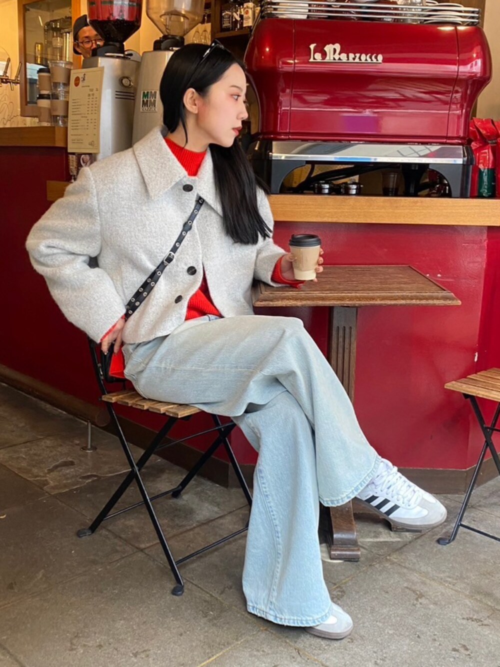 ブルー系のデニムパンツ、グレー系のその他アウター、レッド系のニット/セーターを着用したレディースの秋コーディネートの2枚目の写真