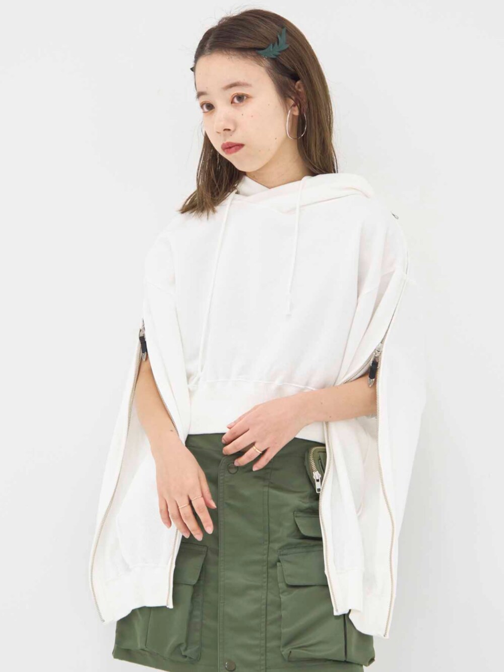 ホワイト系のパーカー、グリーン系のスカートを着用したレディースの冬コーディネートの2枚目の写真