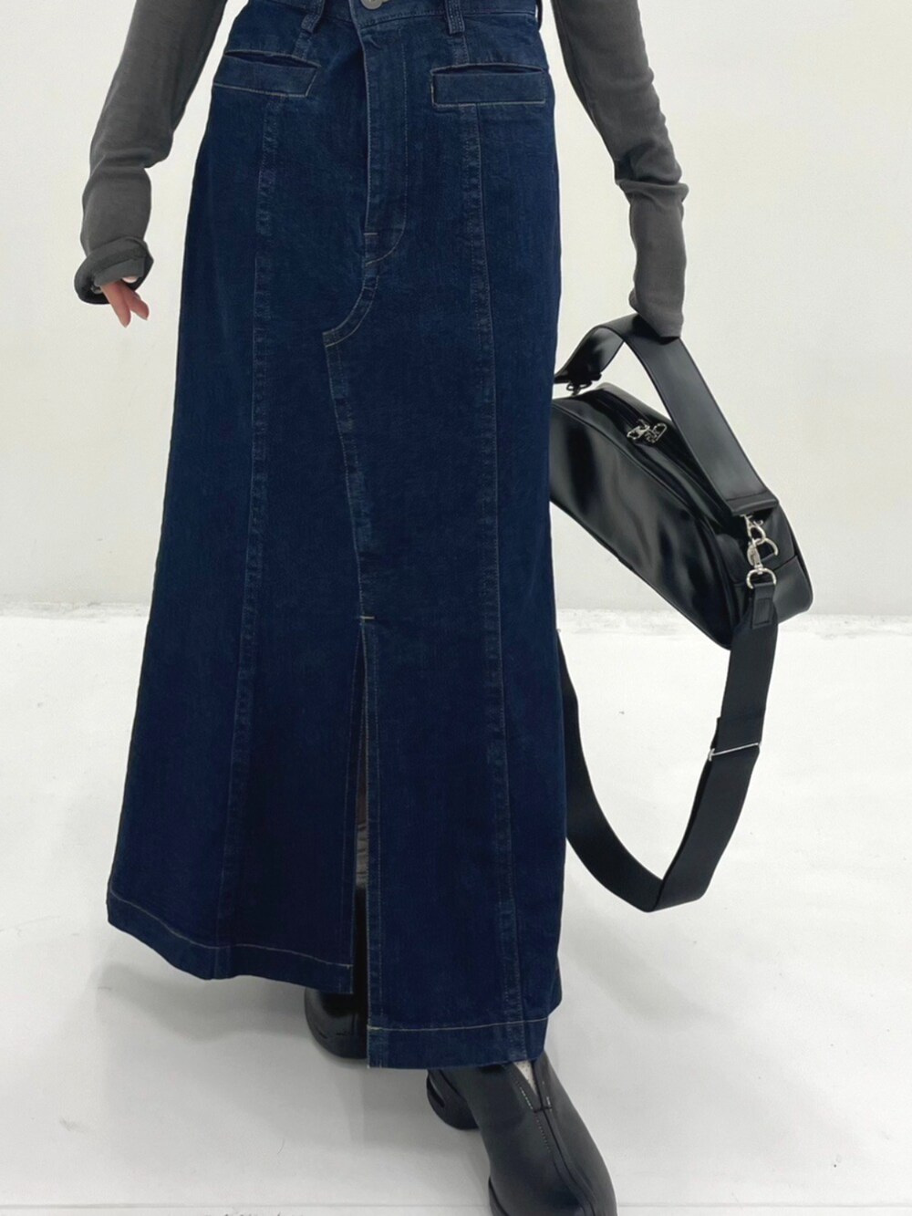 ブラック系のショルダーバッグ、グレー系のTシャツ/カットソー、ブルー系のスカートを着用したレディースの秋コーディネートの3枚目の写真