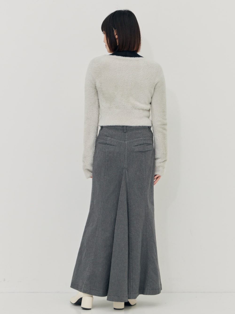 グレー系のカーディガン/ボレロ、ブラック系のニット/セーター、グレー系のスカートを着用したレディースの秋コーディネートの3枚目の写真