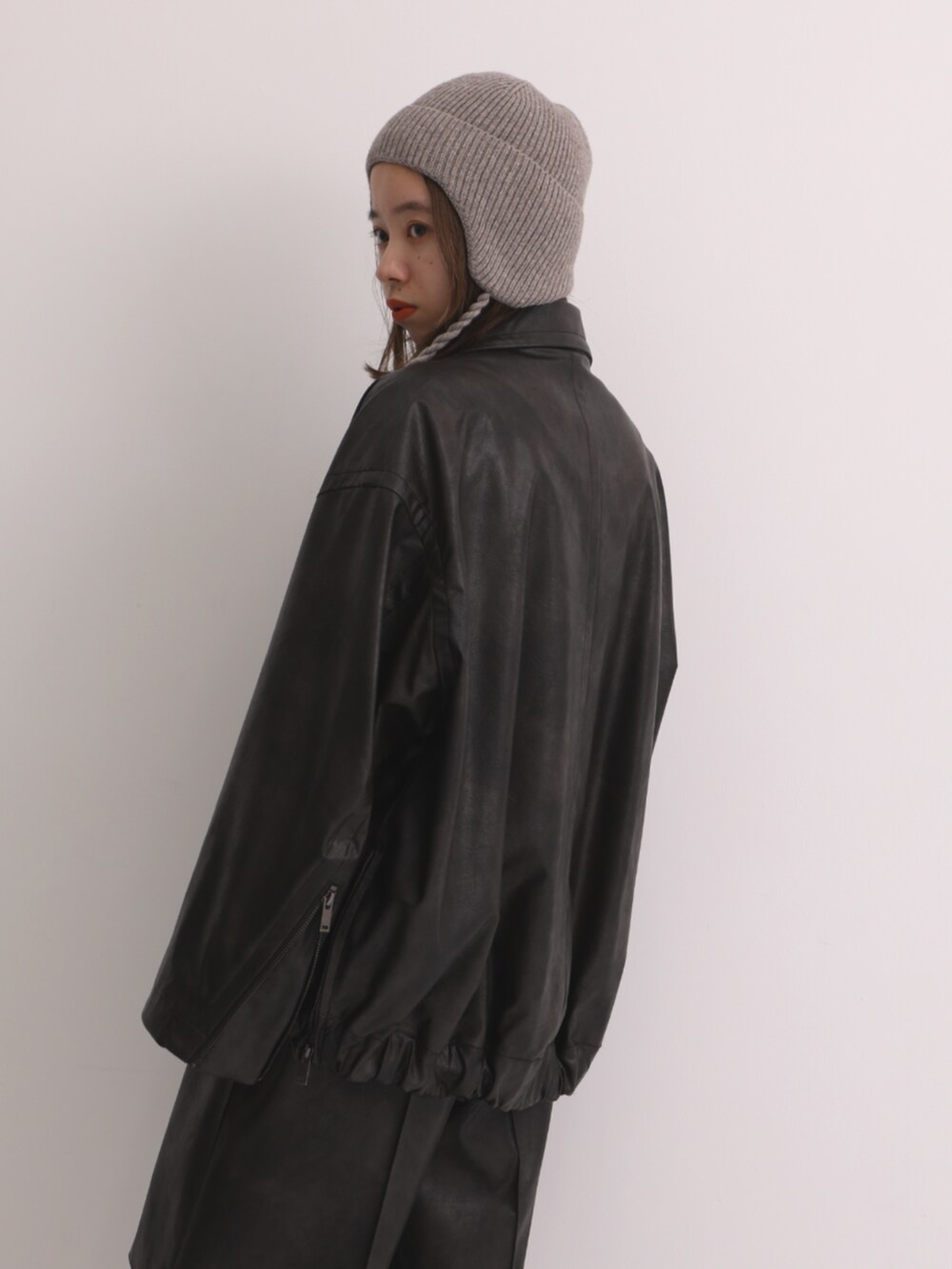 ブラウン系のブルゾン、ベージュ系のニットキャップ/ビーニーを着用したレディースの秋コーディネートの3枚目の写真