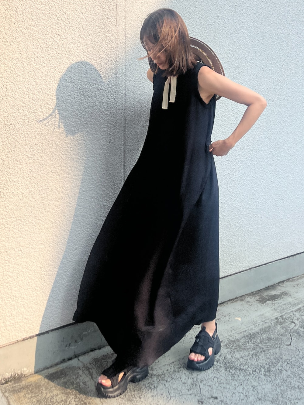 ブラック系のワンピース、ブラック系のサンダルを着用したレディースの夏コーディネートの2枚目の写真