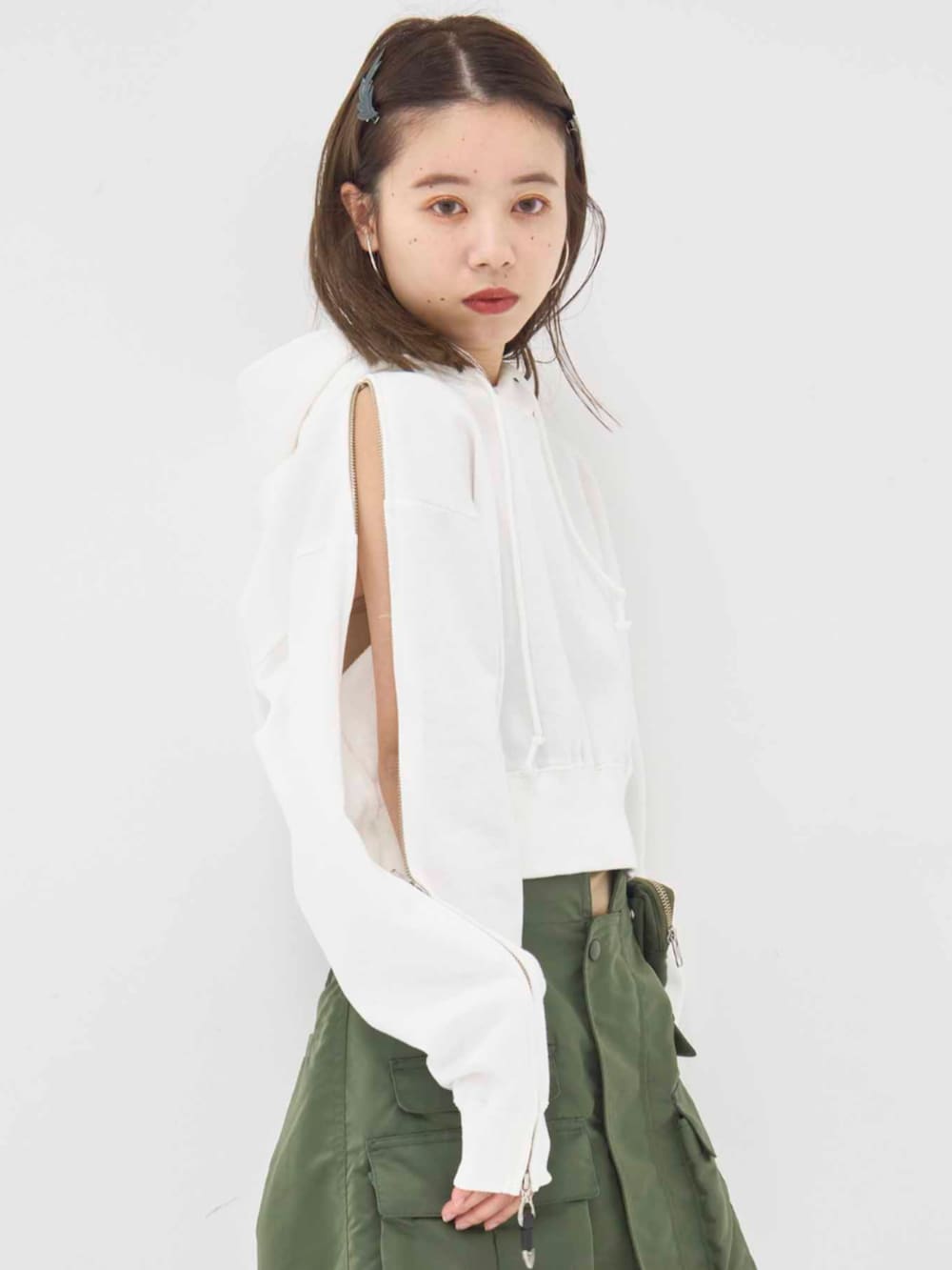 ホワイト系のパーカー、グリーン系のスカートを着用したレディースの冬コーディネートの5枚目の写真