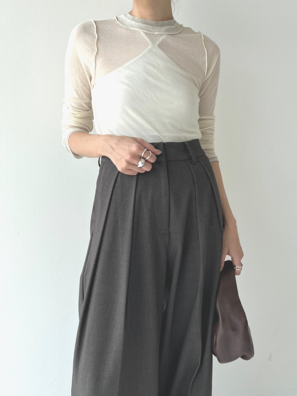 ブラック系のブーツ、ホワイト系のTシャツ/カットソー、グレー系のスラックスを着用したレディースの秋コーディネートの4枚目の写真