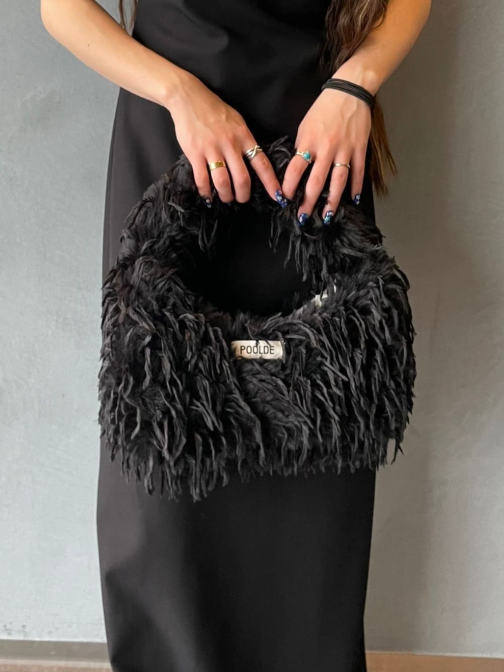 ブラック系のワンピース、ブラック系のショルダーバッグを着用したレディースの秋コーディネートの3枚目の写真