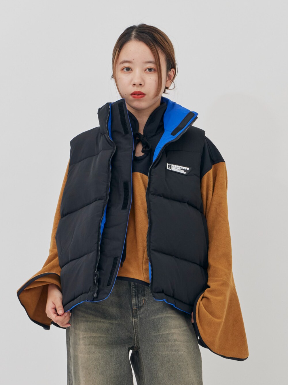 イエロー系のその他トップス、ブルー系のダウンベストを着用したレディースの秋コーディネートの5枚目の写真