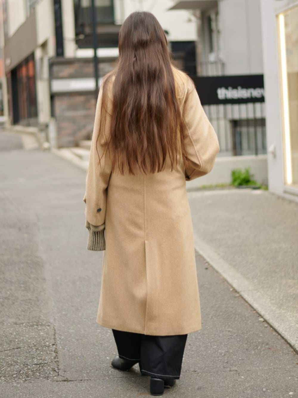 グリーン系のニット/セーター、イエロー系のその他アウターを着用したレディースの冬コーディネートの5枚目の写真