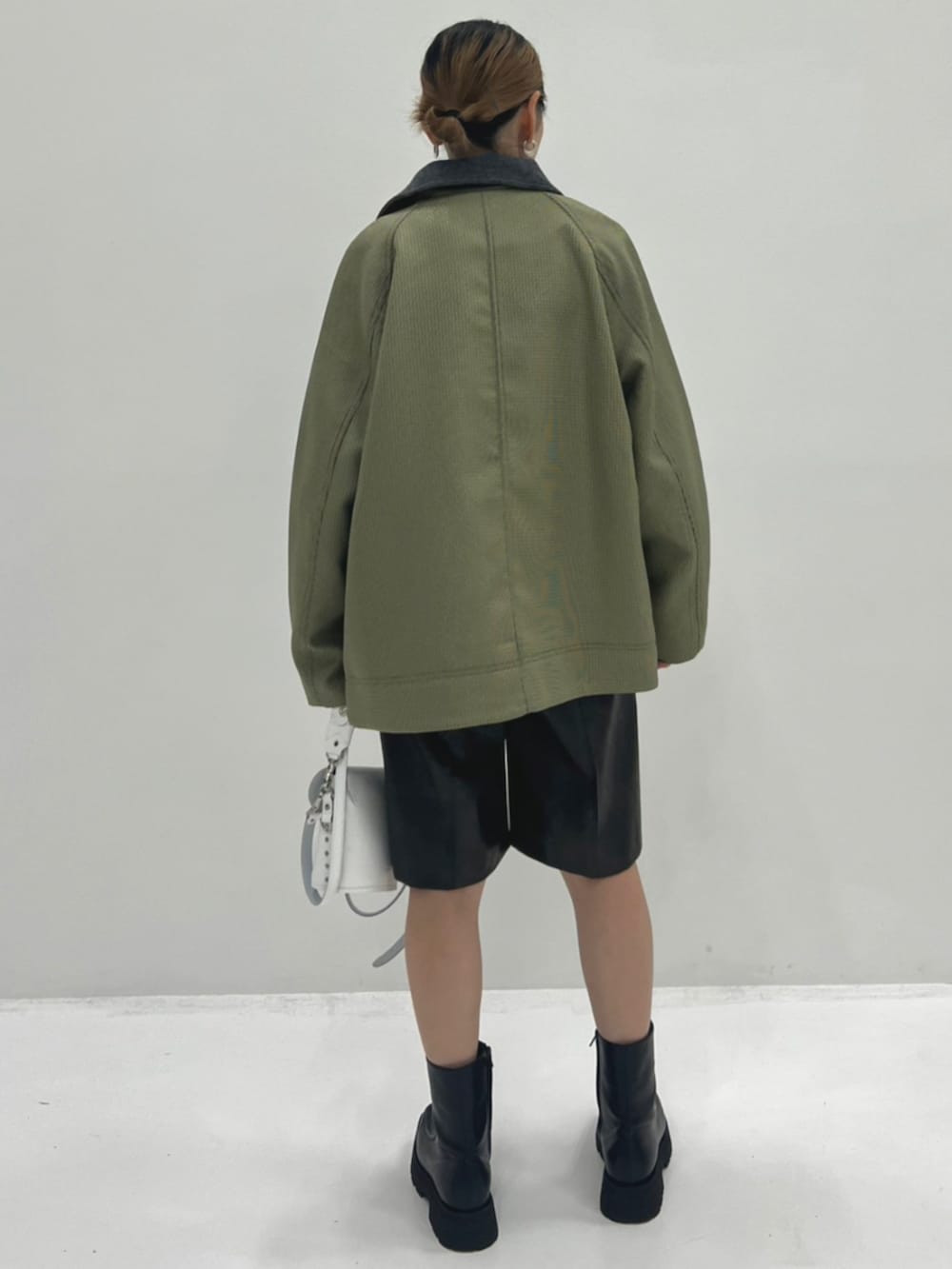 ブラウン系のその他パンツ、ホワイト系のボディバッグ/ウエストポーチ、グリーン系のブルゾンを着用したレディースの秋コーディネートの3枚目の写真