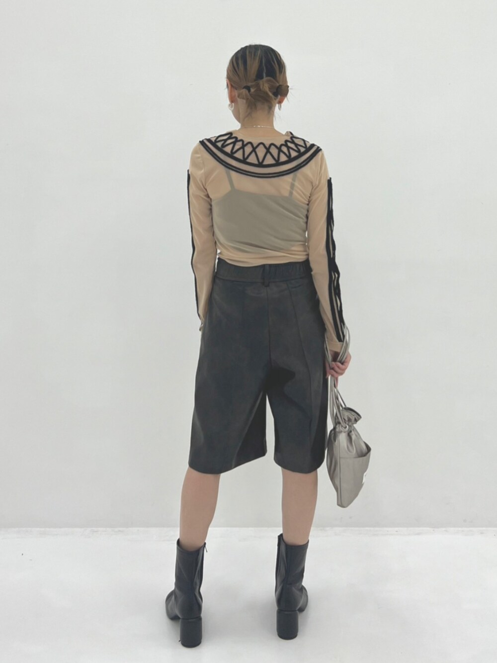 シルバー系のショルダーバッグ、ブラウン系のその他パンツ、ブラック系のブーツを着用したレディースの秋コーディネートの2枚目の写真