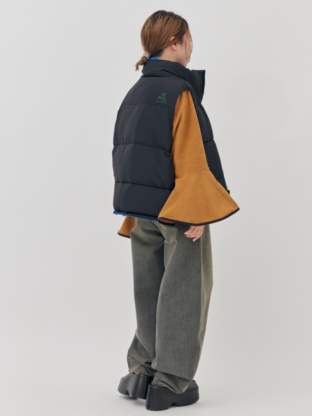 イエロー系のその他トップス、ブルー系のダウンベストを着用したレディースの秋コーディネートの4枚目の写真