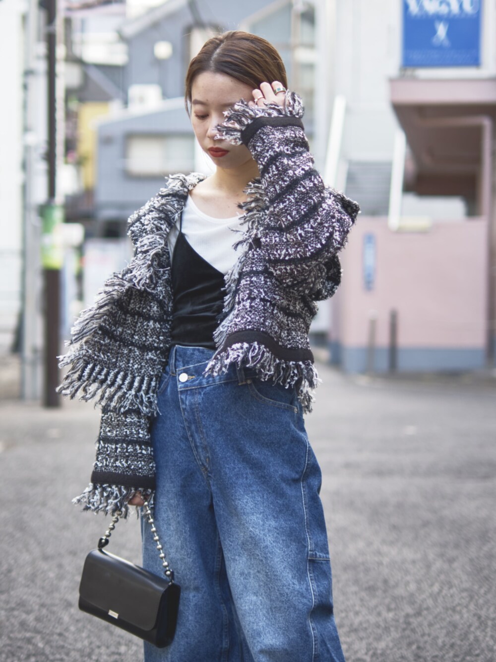 ブラック系のカーディガン/ボレロ、ブルー系のデニムパンツを着用したレディースの冬コーディネートの2枚目の写真