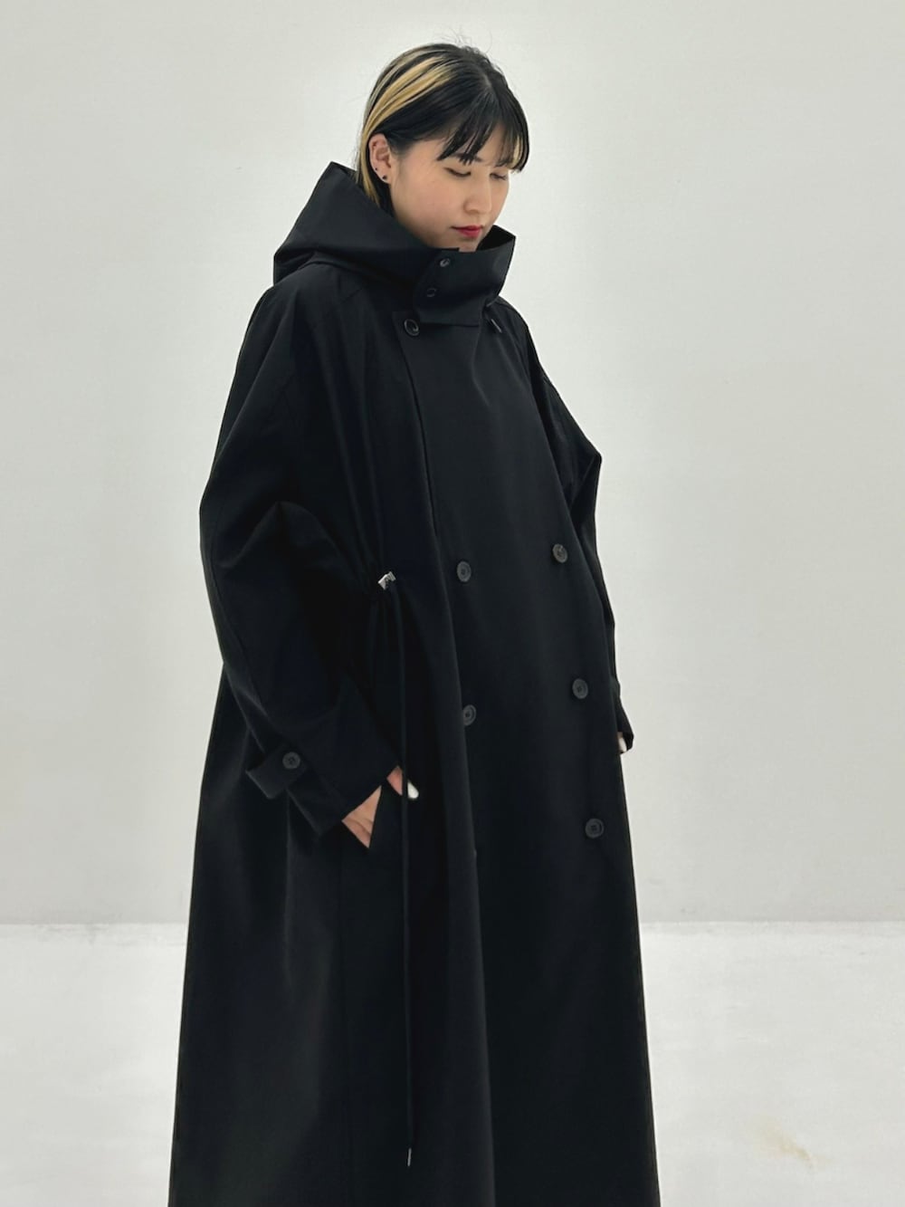 ブラック系のトレンチコートを着用したレディースの秋コーディネートの4枚目の写真