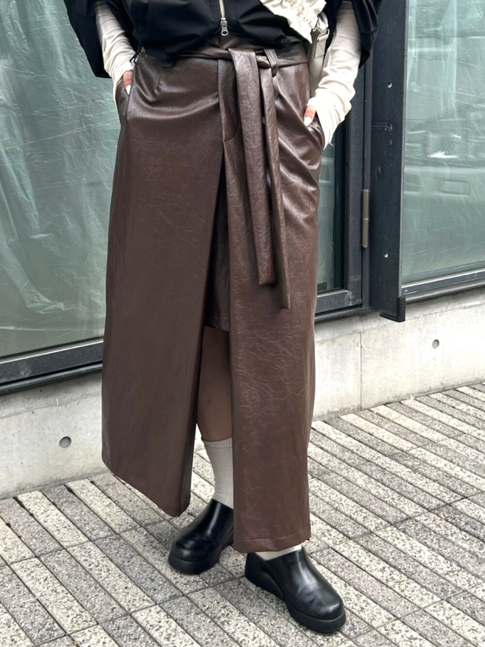 ホワイト系のTシャツ/カットソー、ブラック系のその他アウター、ブラウン系のスカートを着用したレディースの秋コーディネートの3枚目の写真