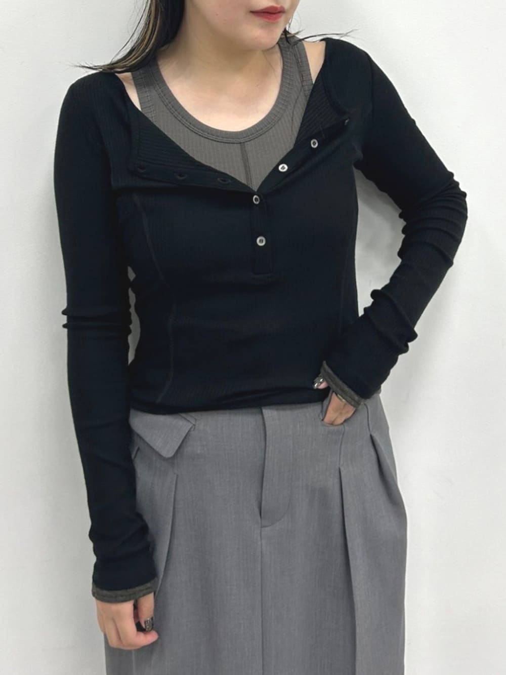 グレー系のタンクトップ、ブラック系のTシャツ/カットソー、グレー系のスカートを着用したレディースの秋コーディネートの3枚目の写真