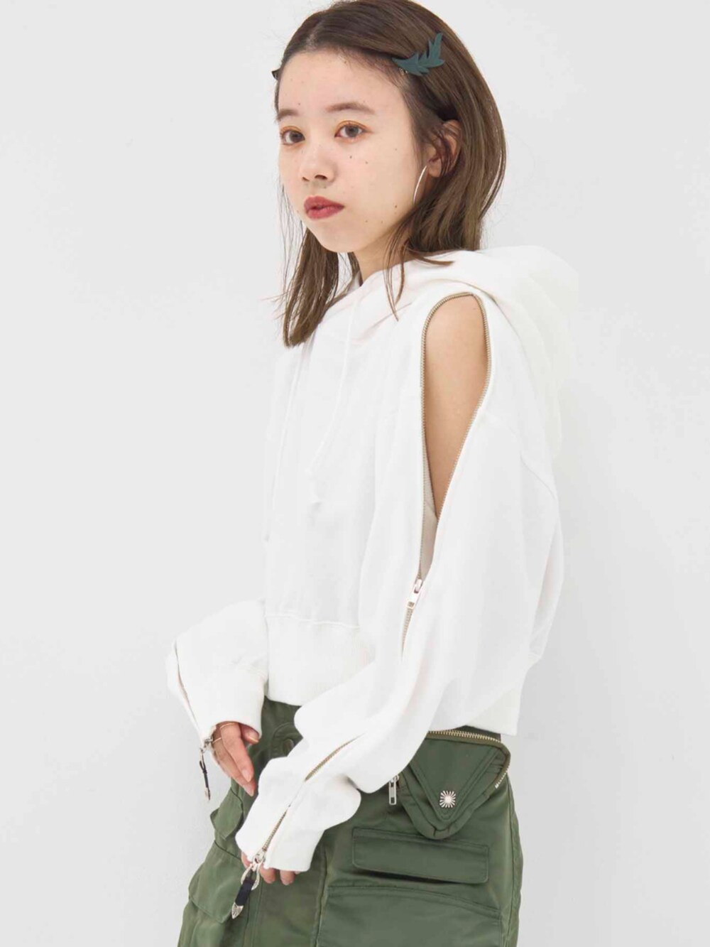 ホワイト系のパーカー、グリーン系のスカートを着用したレディースの冬コーディネートの4枚目の写真