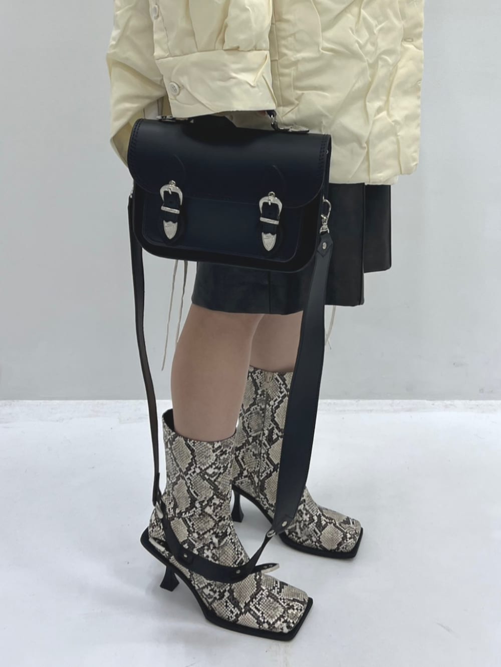 その他のブーツ、ベージュ系のその他アウター、ブラック系のトートバッグを着用したレディースの秋コーディネートの3枚目の写真