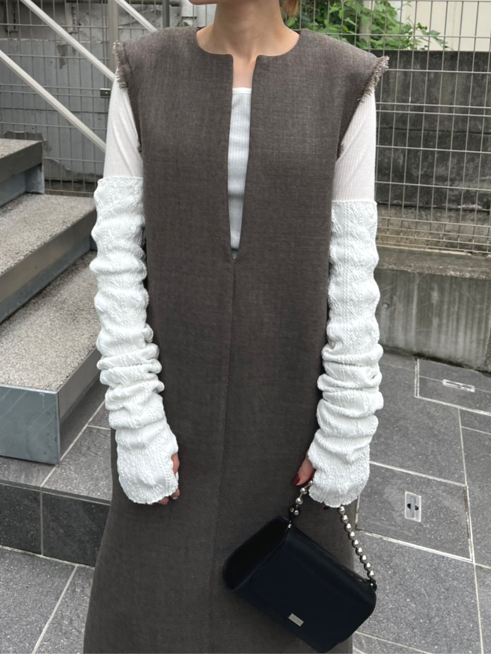 ベージュ系のワンピース、ホワイト系のアームカバーを着用したレディースの秋コーディネートの4枚目の写真