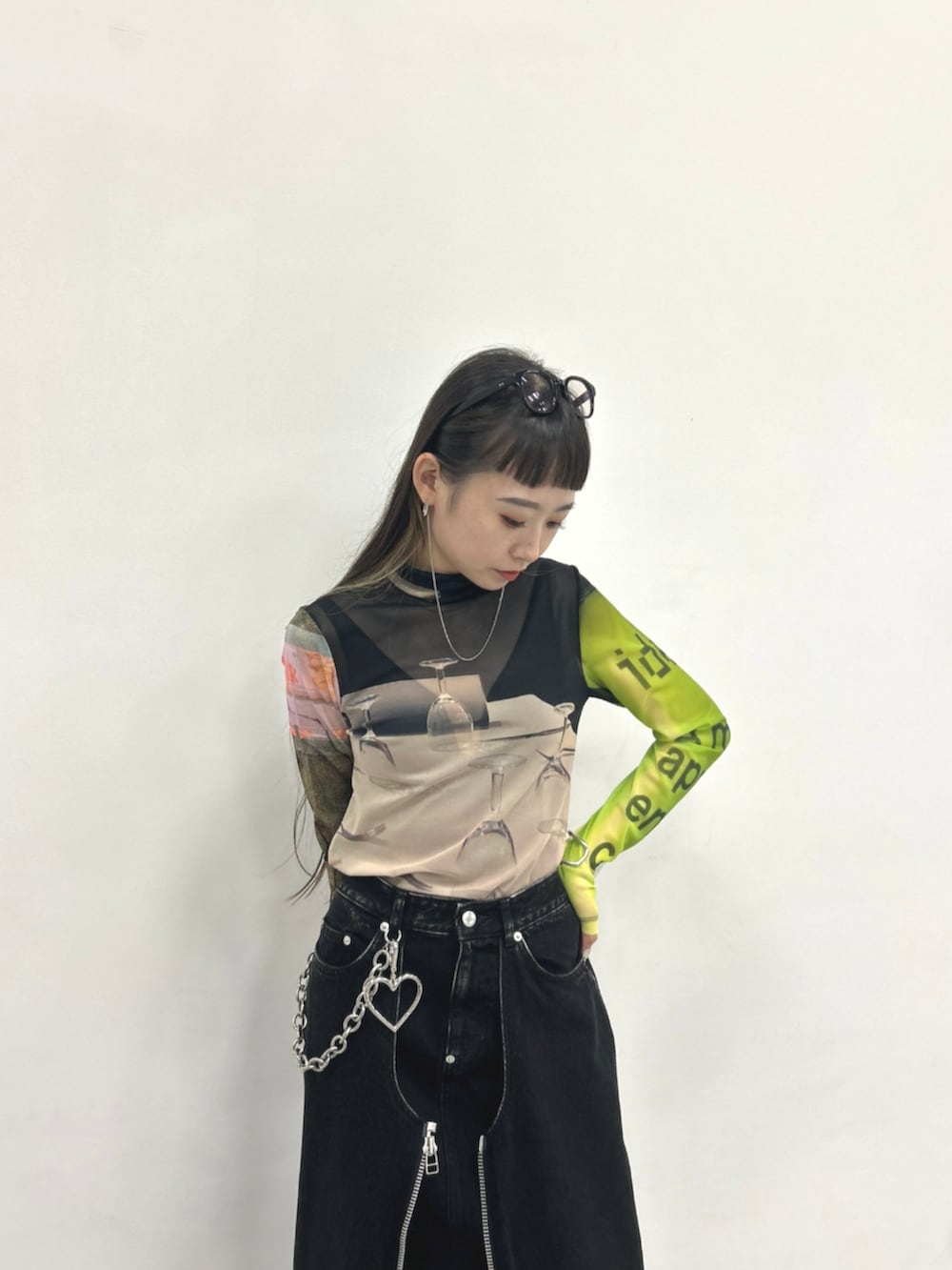 ブラック系のTシャツ/カットソー、ブラック系のデニムスカート、ブラック系のブーツを着用したレディースの秋コーディネートの3枚目の写真