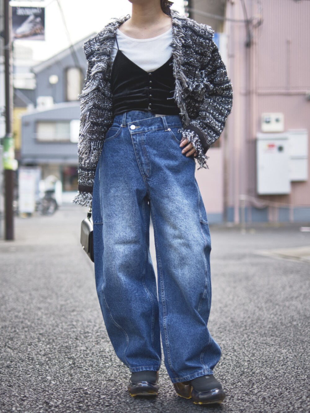 ブラック系のカーディガン/ボレロ、ブルー系のデニムパンツを着用したレディースの冬コーディネートの4枚目の写真