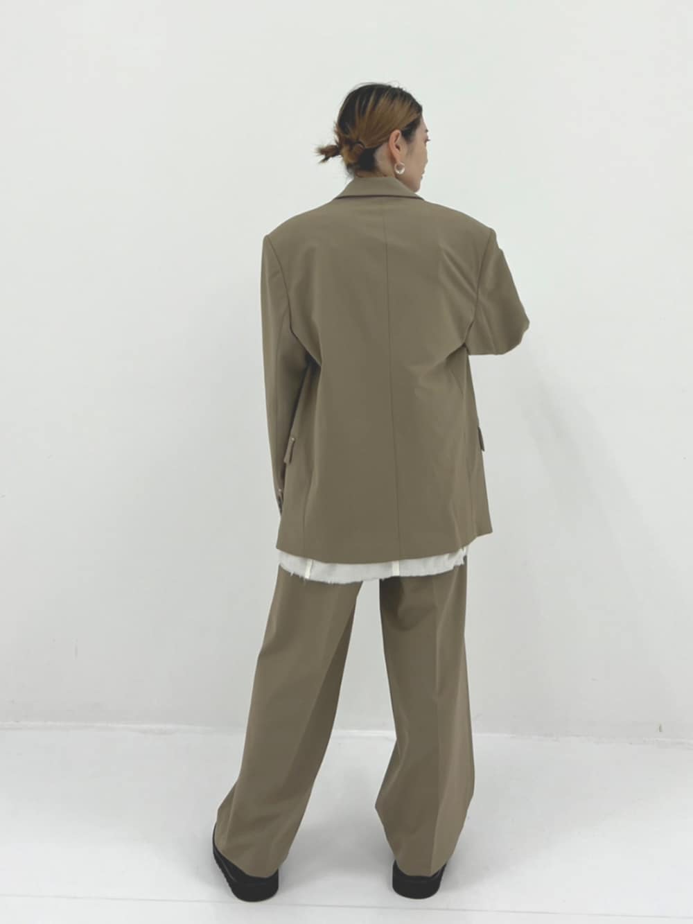 グリーン系のスラックス、グリーン系のテーラードジャケットを着用したレディースの秋コーディネートの2枚目の写真