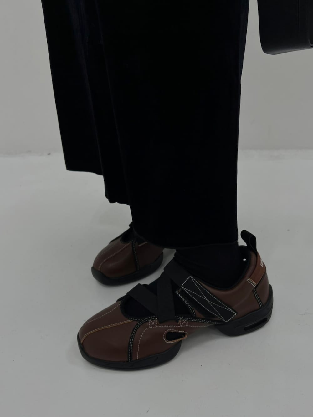 ホワイト系のシャツ/ブラウス、ブラック系のショルダーバッグ、ベージュ系のベストを着用したレディースの秋コーディネートの4枚目の写真