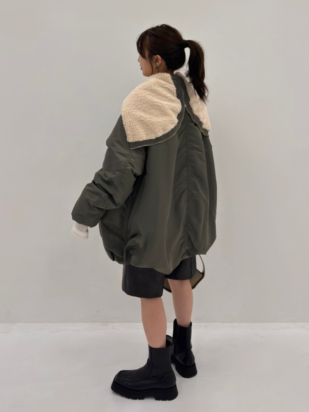 グリーン系のブルゾンを着用したレディースの秋コーディネートの2枚目の写真